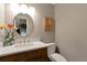 Stylish powder room featuring a modern vanity, round mirror, and neutral décor at 6918 E Easter Pl, Centennial, CO 80112