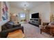 Comfortable living room with couch, TV, patterned chair, and sliding glass door to balcony at 9962 W Victoria Pl # 106, Littleton, CO 80127