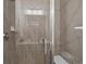 Close-up of a tiled shower with a glass door, featuring modern fixtures and a built-in seat at 9962 W Victoria Pl # 106, Littleton, CO 80127