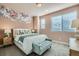 Stylish bedroom with floral wall art, large windows, and a cozy bench at the foot of the bed at 16555 Peak Way, Broomfield, CO 80023