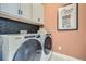 Well-organized laundry room with modern appliances, overhead cabinets, and stylish backsplash at 16555 Peak Way, Broomfield, CO 80023