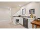 Basement bar area with a wine refrigerator, a mosaic backsplash, white cabinets, and a wood counter at 7420 S Wolff St, Littleton, CO 80128