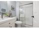 Well-lit bathroom featuring gray and white tiled floors, a walk-in shower, and a white vanity at 7420 S Wolff St, Littleton, CO 80128
