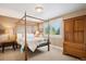Cozy bedroom with a four poster bed, neutral walls, and a window with plantation shutters at 7420 S Wolff St, Littleton, CO 80128