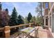 Outdoor deck boasts a dining table with seating and views of the surrounding trees and landscaping at 7420 S Wolff St, Littleton, CO 80128