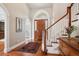Bright foyer with wood floors, white trim and an elegant staircase at 7420 S Wolff St, Littleton, CO 80128