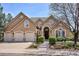 Charming home featuring a three-car garage, stone accents, and a landscaped front yard at 7420 S Wolff St, Littleton, CO 80128