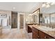 Main bathroom with double sinks, granite counters, tile floors, a glass enclosed shower, and a soaking tub at 7420 S Wolff St, Littleton, CO 80128