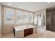 Bright bathroom featuring a built in soaking tub with storage, tile floors, and a glass enclosed shower at 7420 S Wolff St, Littleton, CO 80128
