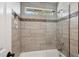 Modern shower featuring beige tiling, mosaic accents, a built-in niche, and a rainfall shower head at 7420 S Wolff St, Littleton, CO 80128