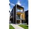 Modern three story home with a sleek black exterior, wood accents, and well-maintained landscaping at 4815 W 10Th Ave, Denver, CO 80204