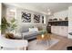 A cozy living room with neutral decor features a modern couch, unique artwork, and stylish wet bar at 4815 W 10Th Ave, Denver, CO 80204