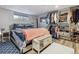 Cozy bedroom features built-in wardrobe, storage bench, and a soft blue patterned rug at 12023 W Virginia Ave, Lakewood, CO 80228