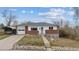 Charming ranch-style home with a brick facade, attached garage, and mature trees under a bright blue sky at 12023 W Virginia Ave, Lakewood, CO 80228