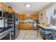 Functional kitchen with stainless steel appliances, wooden cabinets, and tile flooring at 12023 W Virginia Ave, Lakewood, CO 80228
