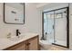 Bright bathroom featuring a modern vanity, a glass-enclosed shower with seating, and subway tile walls at 2 N Jasmine St, Denver, CO 80220
