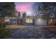 Single-story home with brick facade, attached garage, and well-maintained landscaping at dusk at 2 N Jasmine St, Denver, CO 80220