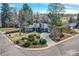 A beautifully landscaped ranch style home featuring mature trees, a circular driveway, and a well-manicured front yard at 2 N Jasmine St, Denver, CO 80220