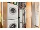 Compact utility room features stacked washer/dryer, hot water tank, and organized storage solutions at 780 Walnut St # A, Boulder, CO 80302