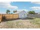 Good-sized backyard with a new wooden fence, some grass, and a small shed at 6691 Hooker St, Denver, CO 80221