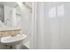 Bathroom with traditional finishes, updated fixtures, and a large round mirror at 6691 Hooker St, Denver, CO 80221