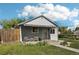 Charming single-story home with a covered front porch, green lawn, and blossoming plants adding curb appeal at 6691 Hooker St, Denver, CO 80221