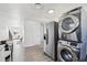 Open-concept kitchen and dining area with modern appliances and stacked washer/dryer, creating a functional and stylish space at 6691 Hooker St, Denver, CO 80221