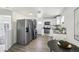 Modern kitchen featuring stainless steel appliances, stacked laundry and a dining area, offering functionality and style at 6691 Hooker St, Denver, CO 80221