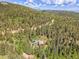 Aerial view of a home nestled in a forest of tall trees in a mountainous area at 11182 S Barney Gulch Rd, Conifer, CO 80433