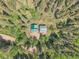 Aerial view of a wooden home with a deck nestled in a lush, green forest in a private wooded community at 11182 S Barney Gulch Rd, Conifer, CO 80433