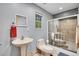 Bright bathroom featuring a pedestal sink, toilet, a glass-enclosed shower, and ample natural light at 11182 S Barney Gulch Rd, Conifer, CO 80433