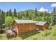 Stunning two-story wooden home with a metal roof, wooden deck, and gorgeous views of the surrounding forest at 11182 S Barney Gulch Rd, Conifer, CO 80433