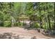 Exterior view of a home with a two-car garage and driveway, set amongst lush greenery and trees at 11182 S Barney Gulch Rd, Conifer, CO 80433