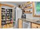 Kitchen features stainless steel appliances, custom wooden shelves and generous pantry space at 11182 S Barney Gulch Rd, Conifer, CO 80433