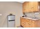 Functional kitchenette with wooden cabinets, sink, countertop space, and a compact refrigerator at 11182 S Barney Gulch Rd, Conifer, CO 80433