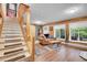 Cozy living room featuring wood accents, natural light, and staircase leading to the upper level at 11182 S Barney Gulch Rd, Conifer, CO 80433