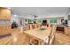 Open-concept living and dining area with hardwood floors, a large dining table, and a comfortable seating area at 11182 S Barney Gulch Rd, Conifer, CO 80433