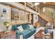 Cozy living room featuring a comfortable couch, wooden accents, and an open staircase at 11182 S Barney Gulch Rd, Conifer, CO 80433
