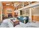 Spacious living room with fireplace and wood-paneled accent wall adjacent to dining area and loft at 11182 S Barney Gulch Rd, Conifer, CO 80433