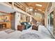Cozy living room featuring a wood-burning fireplace, vaulted ceilings, log railing, and lots of natural light at 11182 S Barney Gulch Rd, Conifer, CO 80433