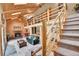 Beautiful living room boasting vaulted ceilings, a fireplace, log railing, and staircase leading to the upper level at 11182 S Barney Gulch Rd, Conifer, CO 80433