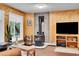 Cozy living room with wood-paneled walls, stone fireplace, hardwood floors, and large windows at 11182 S Barney Gulch Rd, Conifer, CO 80433