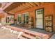Covered front porch with firewood storage, bench, and seating area for relaxing and enjoying the outdoors at 11182 S Barney Gulch Rd, Conifer, CO 80433