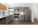 Modern kitchen features stainless steel appliances, sleek gray cabinets, and granite countertops offering style at 17767 E 54Th Ave, Denver, CO 80249
