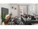Stylish living room featuring modern furniture, large windows, and seamless access to dining area, ideal for entertaining at 17767 E 54Th Ave, Denver, CO 80249