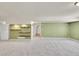 Spacious basement area with shelving and neutral carpeting, offering versatile living space at 3406 Purcell St, Brighton, CO 80601