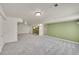 Large basement area with shelving, neutral carpeting, and multiple access doors at 3406 Purcell St, Brighton, CO 80601