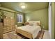 Bedroom with green walls, includes a decorative dresser and a large window at 3406 Purcell St, Brighton, CO 80601