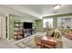 Comfortable living room featuring a large TV, shelving, and a stylish area rug at 3406 Purcell St, Brighton, CO 80601