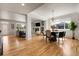 Open-concept living room with hardwood floors, fireplace, and dining area at 3406 Purcell St, Brighton, CO 80601